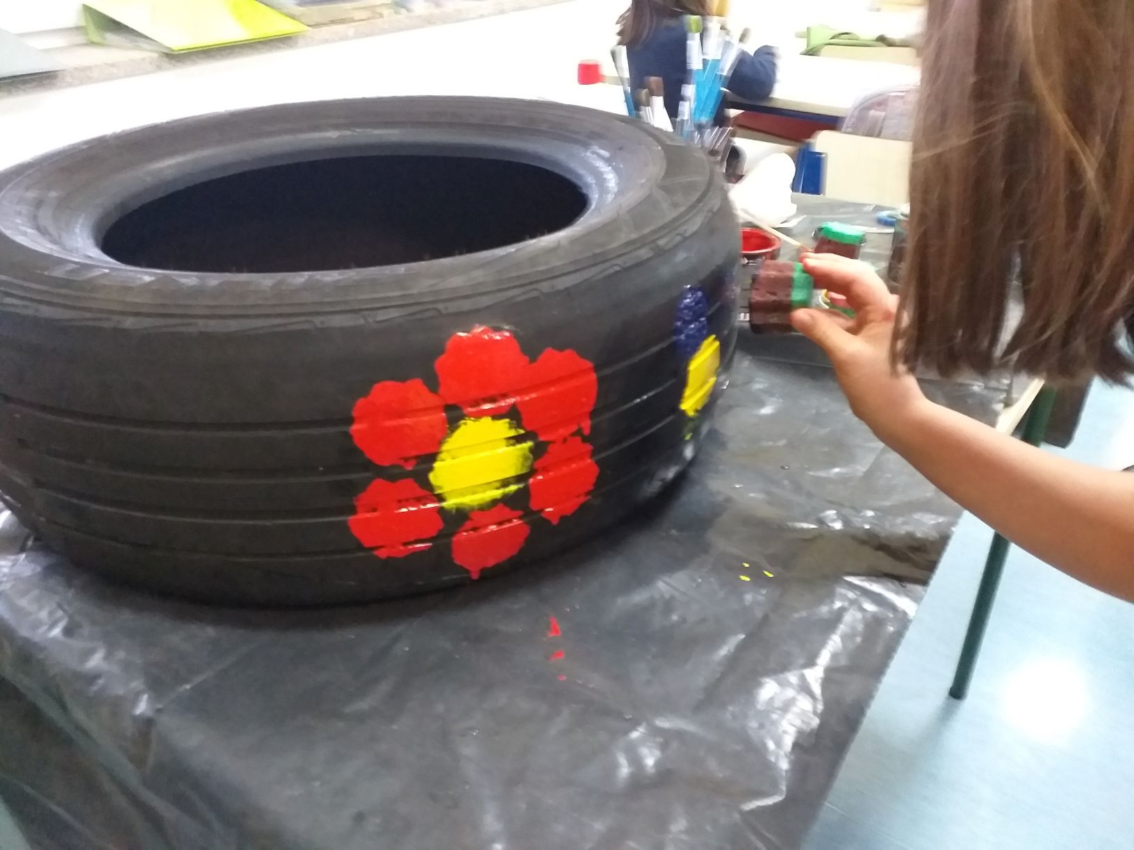 Estamos a decorar os pneus, para tornar a horta mais divertida.